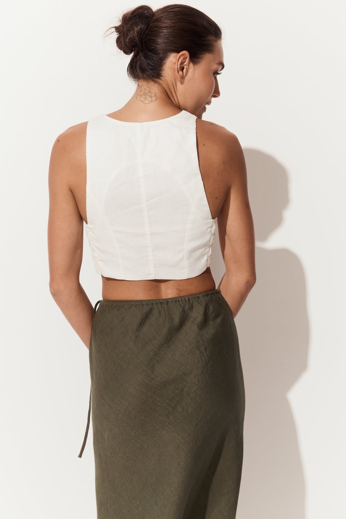 Riley Bias Linen Midi Skirt in Khaki - close up back view of woman wearing skirt paired with Ari linen ivory vest - Lilly Pilly Collection