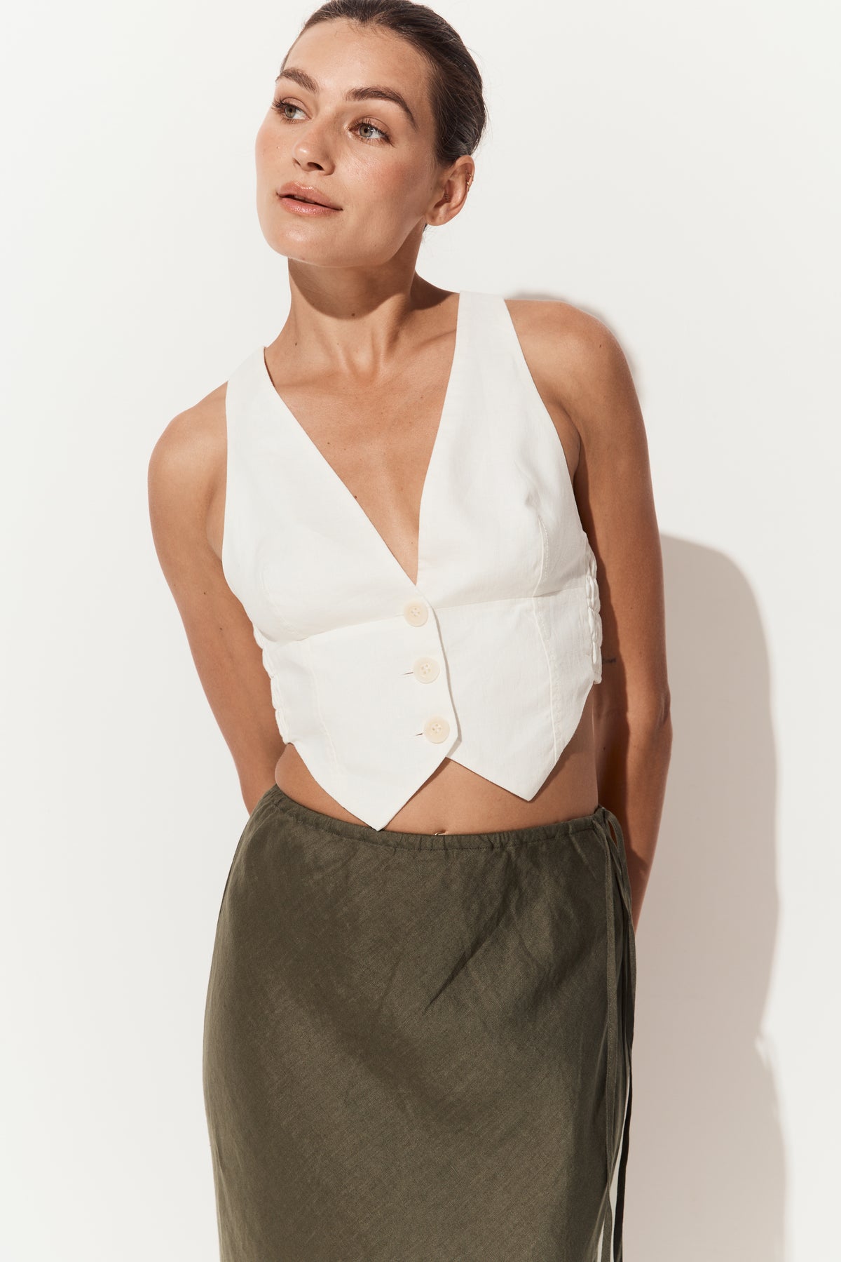 Riley Bias Linen Midi Skirt in Khaki - close up front view of woman wearing skirt paired with Ari linen ivory vest - Lilly Pilly Collection