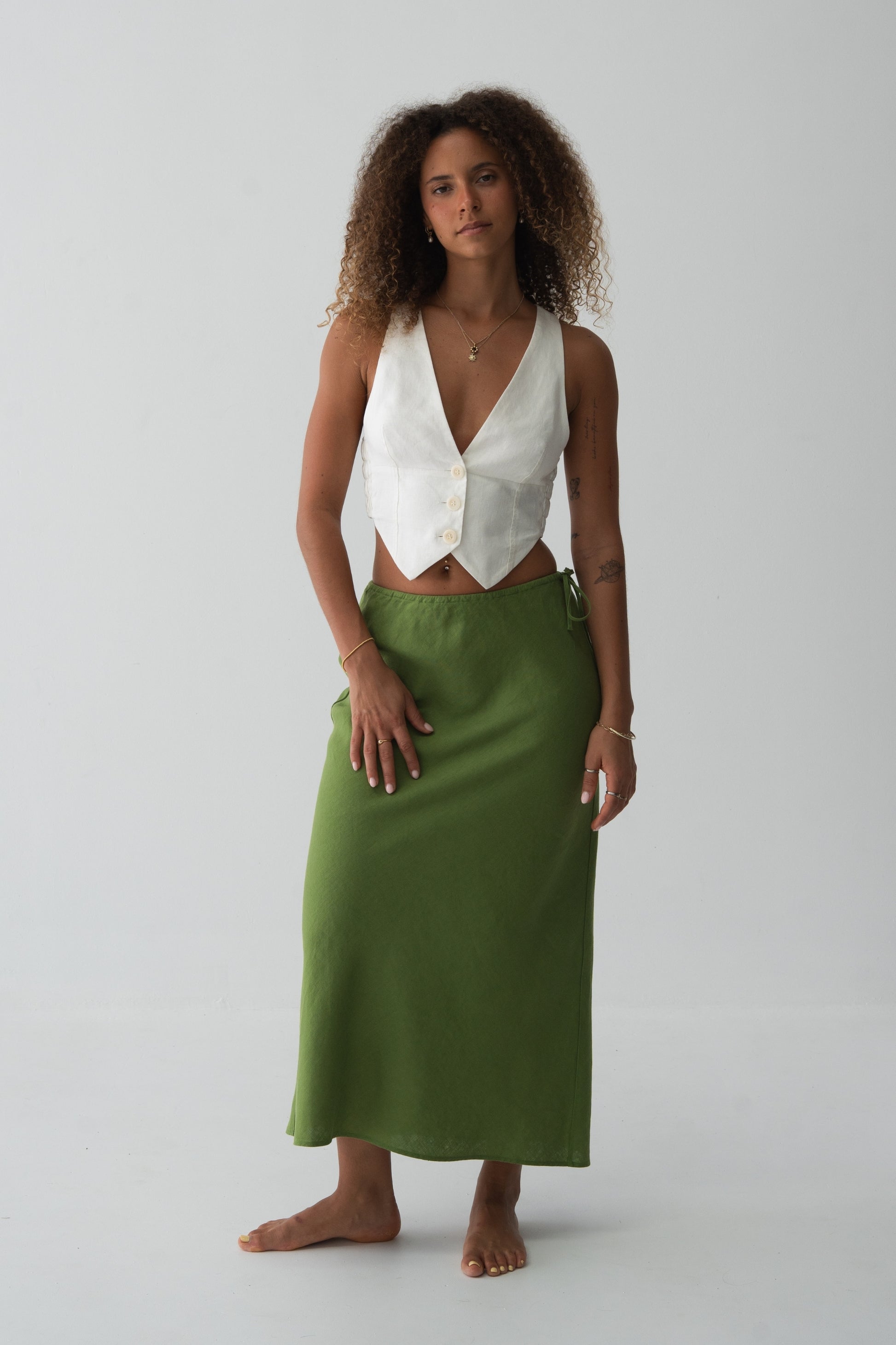 Riley Bias Linen Midi Skirt in Lime Green - full length front view, bias-cut midi length, side tie detail, worn with ivory waistcoat crop top, gold necklace - Lilly Pilly Collection