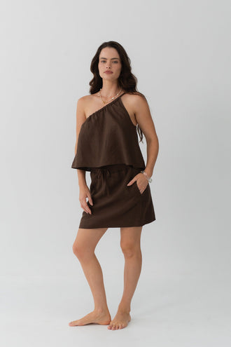 Romy Linen Top in Chocolate - full length front view, one-shoulder neckline, styled with Anelle Linen Mini Skirt in Chocolate, grey studio - Lilly Pilly Collection