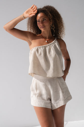 Romy Linen Top in Oatmeal - three-quarter view, one-shoulder gathered neckline, styled with matching Gaia Linen Shorts - Lilly Pilly Collection