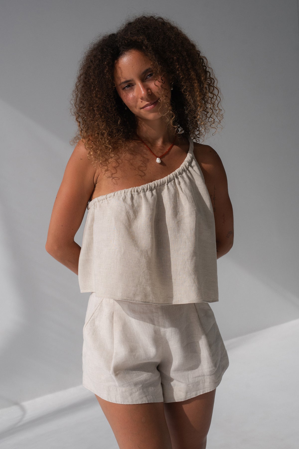 Romy Linen Top in Oatmeal - front view, one-shoulder gathered neckline, styled with matching Gaia Linen Shorts - Lilly Pilly Collection