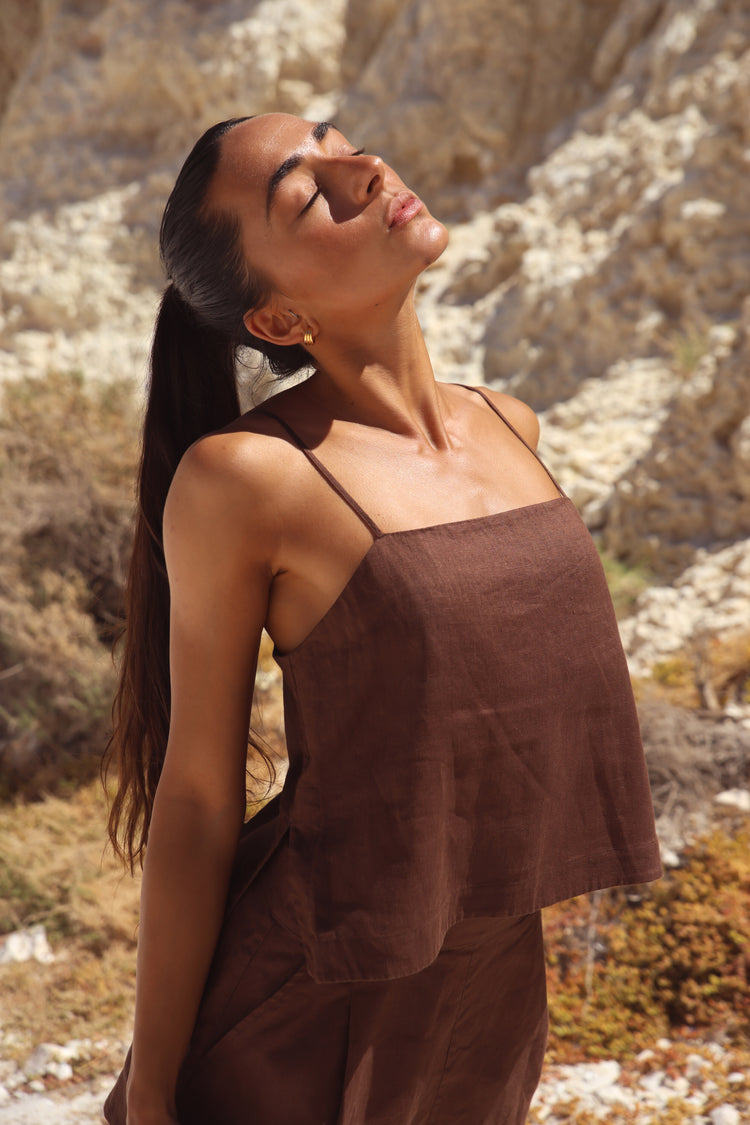 Rosa Linen Cami in Chocolate - side view, square neckline and spaghetti straps, styled with matching chocolate linen shorts, rocky cliff backdrop - Lilly Pilly Collection
