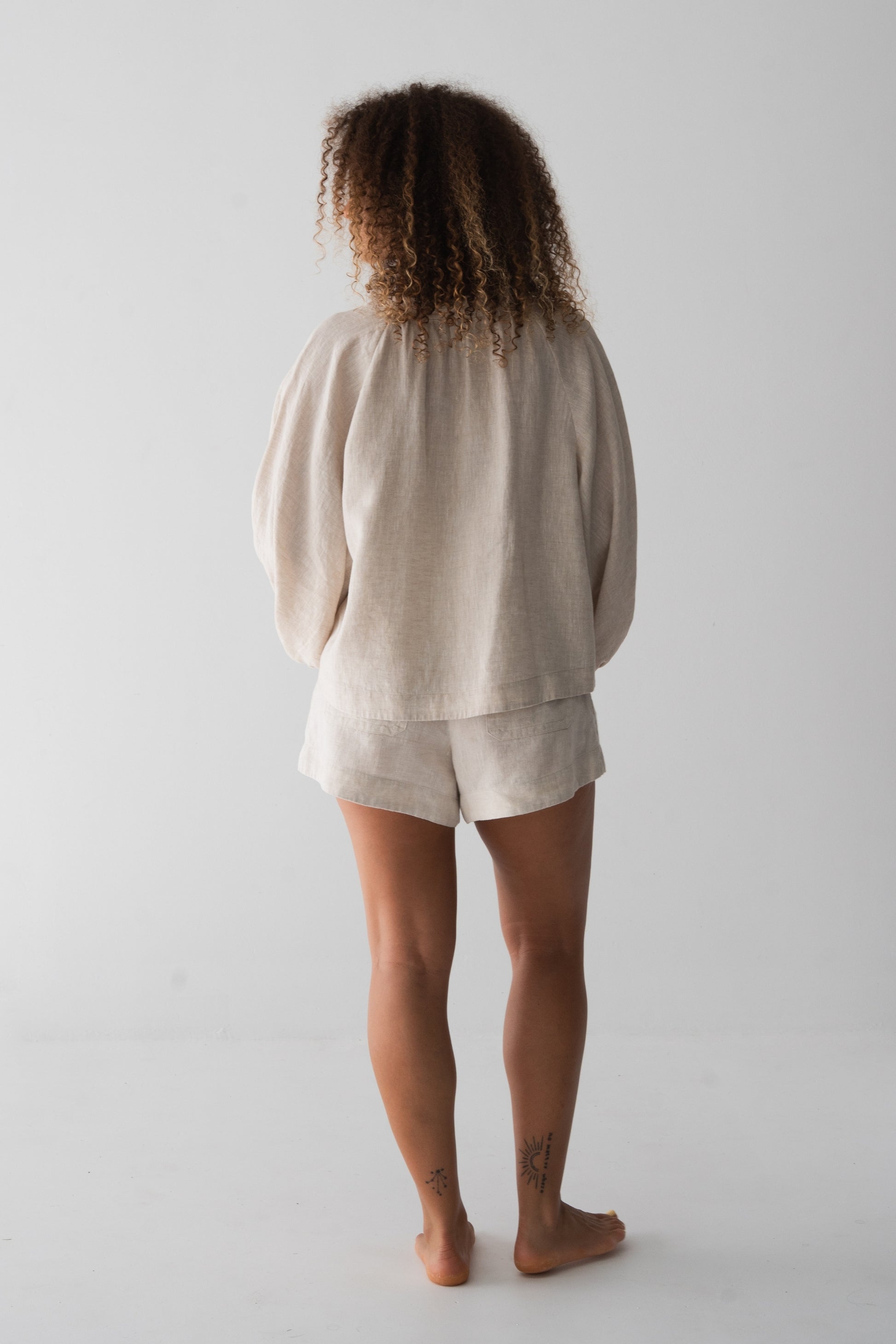 Rowan Linen Shirt in Oatmeal - back view, gathered back and puff sleeves, styled with matching Gaia Linen Shorts - Lilly Pilly Collection