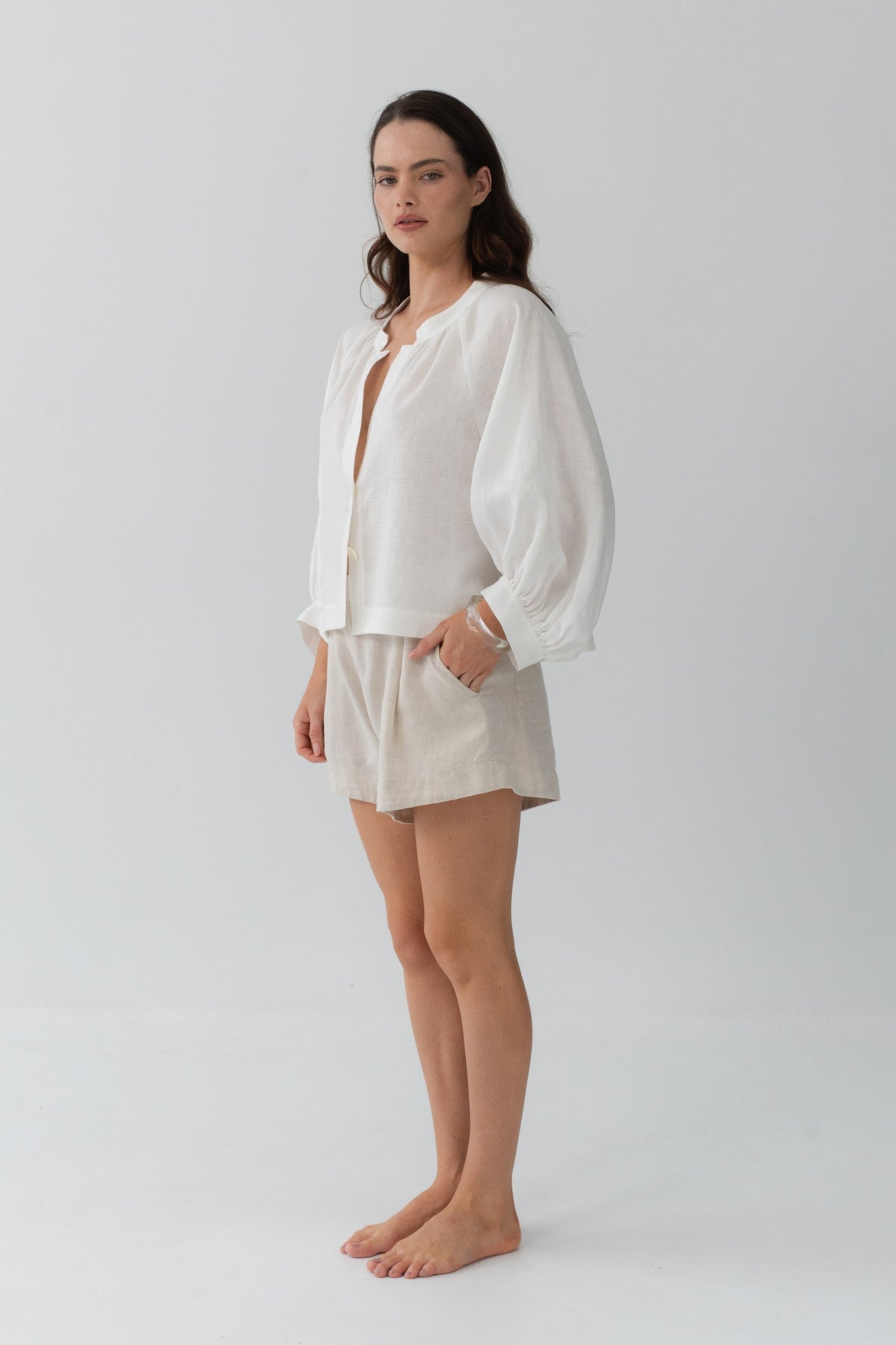 Rowan Linen Shirt in Ivory - side profile, puff sleeves and cropped hem, styled with Gaia Linen Shorts in Oatmeal - Lilly Pilly Collection