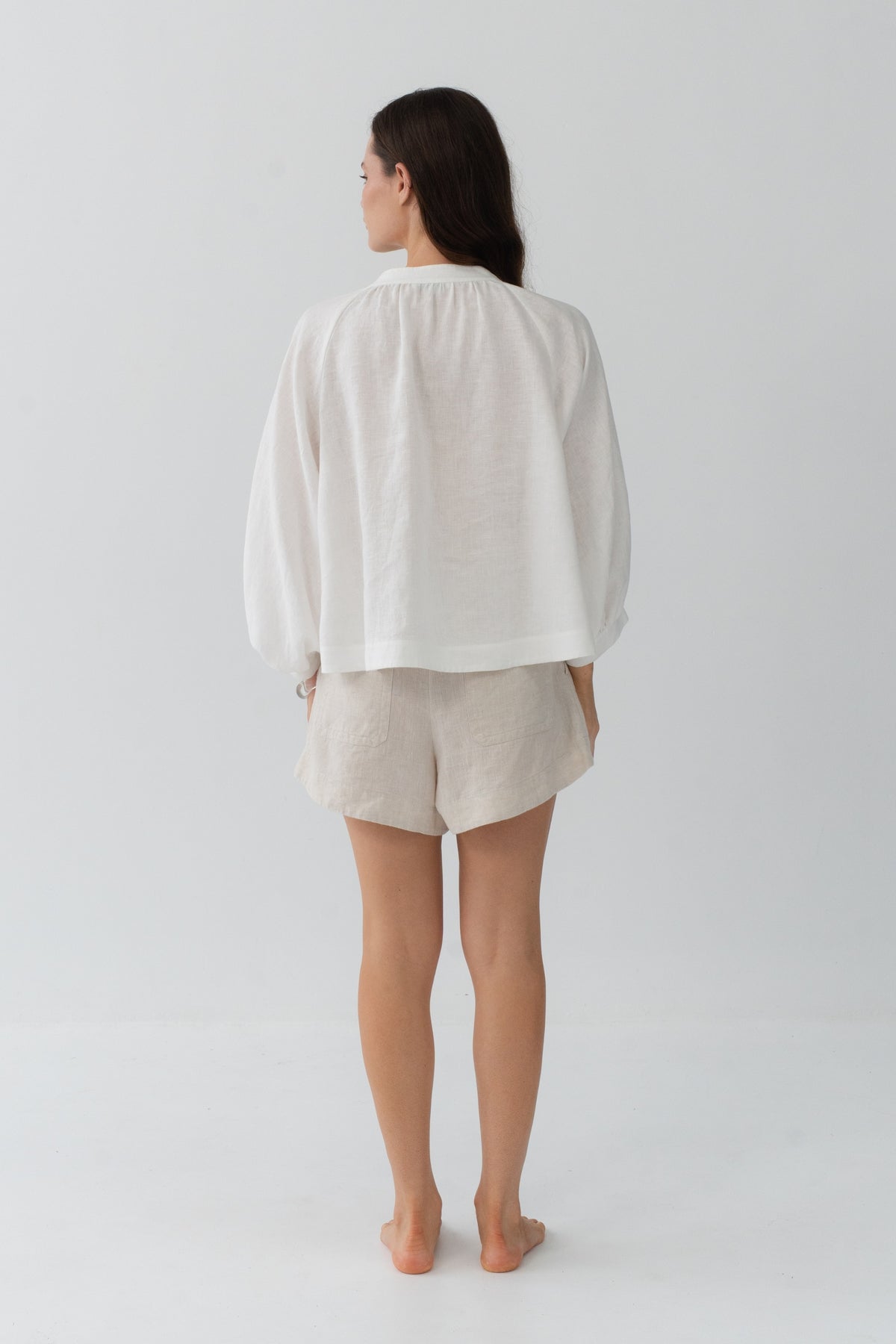 Rowan Linen Shirt in Ivory - back view, gathered back and puff sleeves, styled with Gaia Linen Shorts in Oatmeal - Lilly Pilly Collection