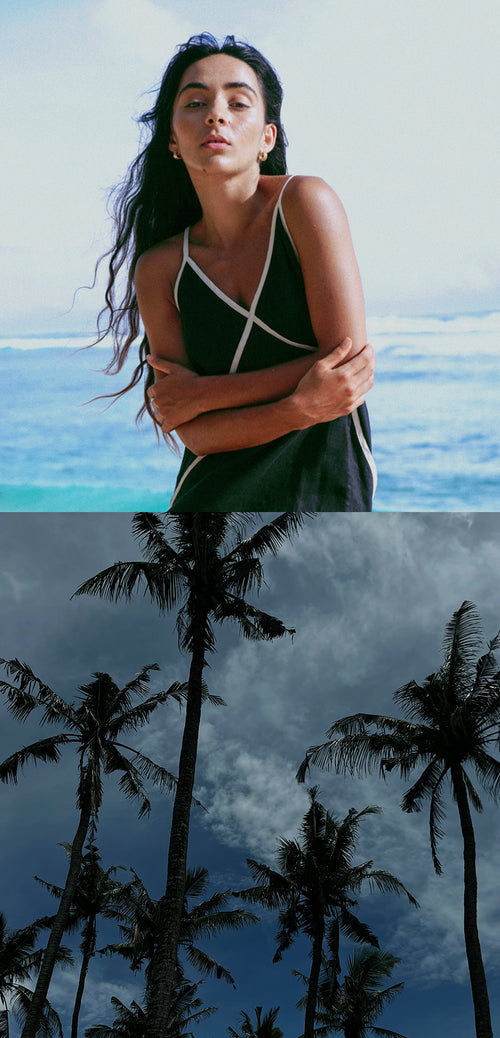 LILLY PILLY woman wearing Azalea Black linen dress by the seaside above Palms trees