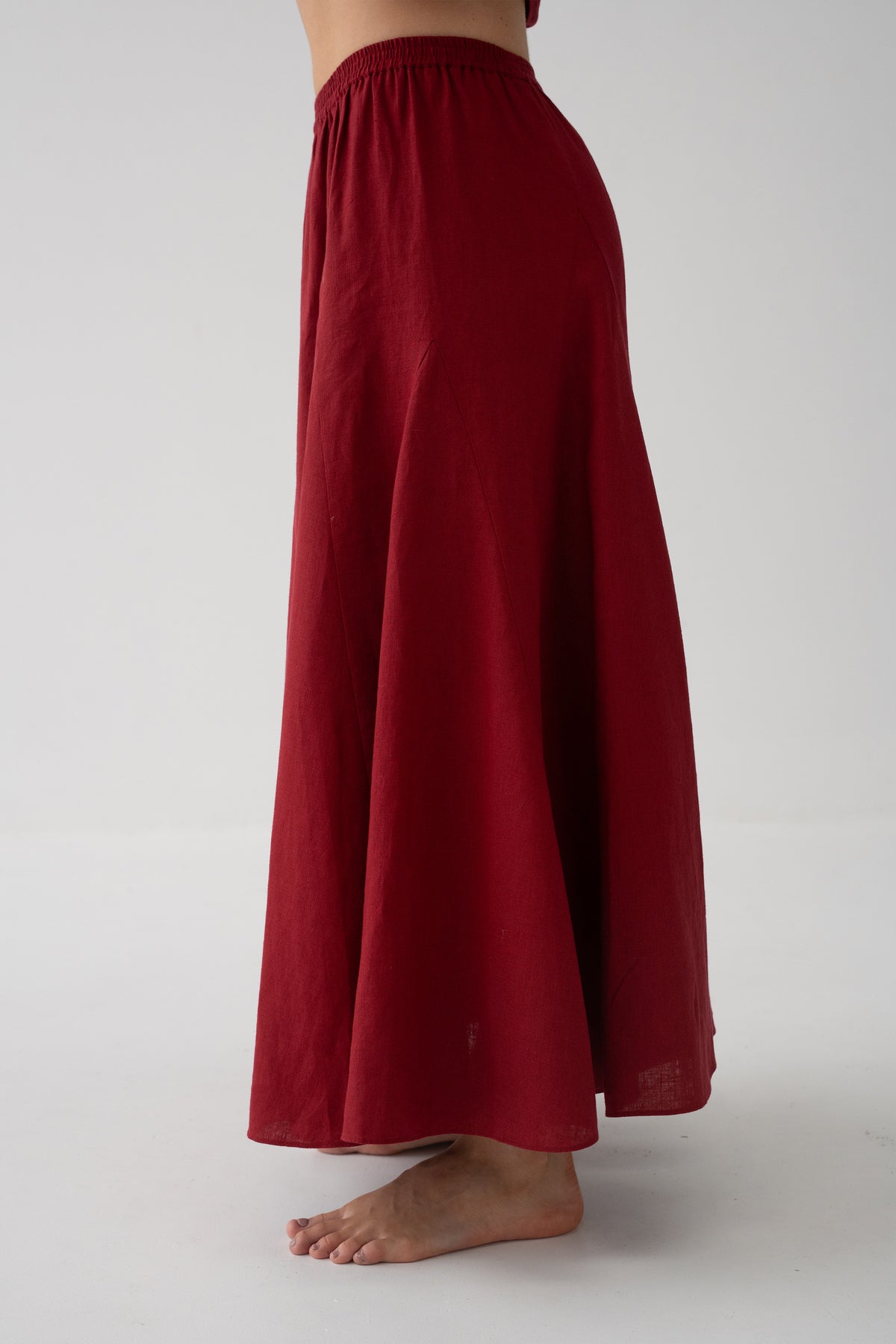 Stella Linen Maxi Skirt in Cherry Red - side view showing full A-line maxi silhouette and elasticated waistband, studio backdrop - Lilly Pilly Collection