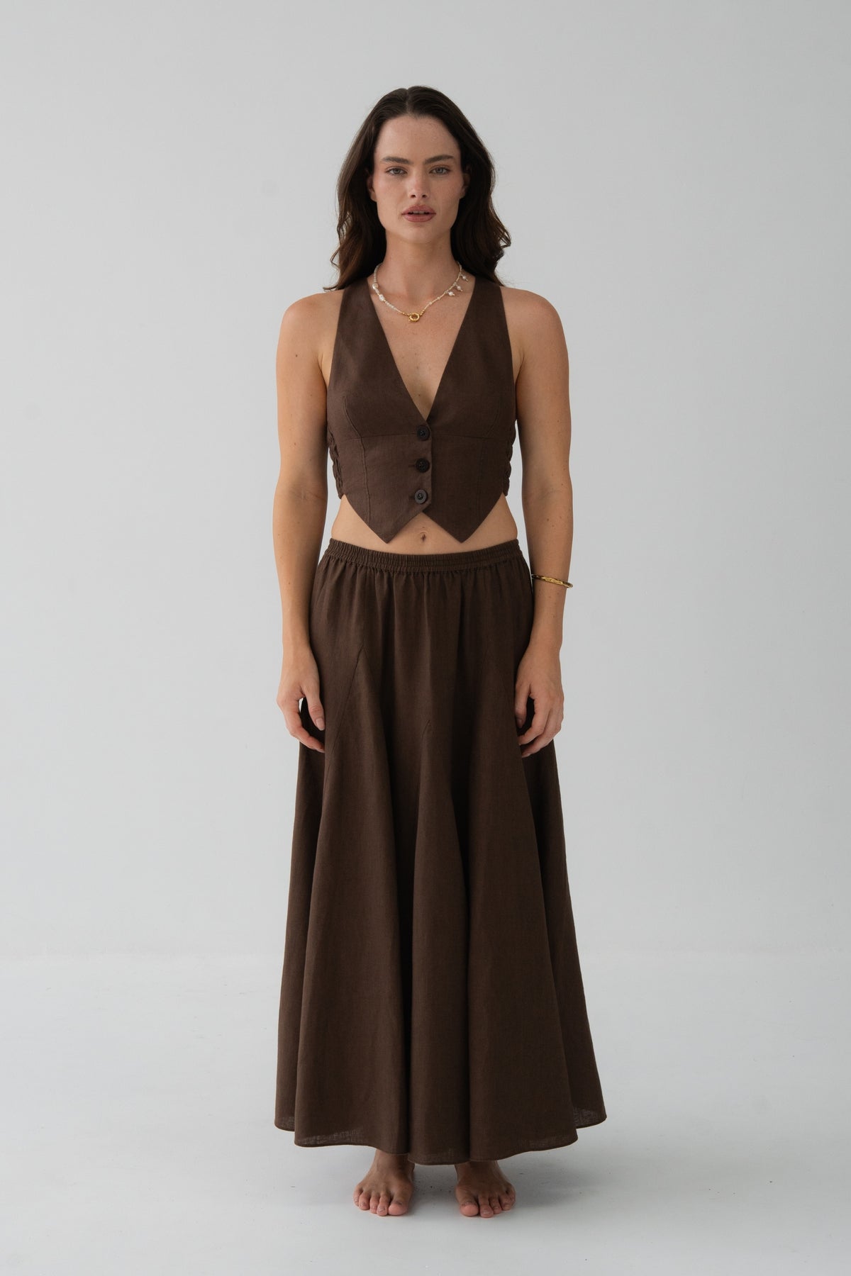 Stella Linen Maxi Skirt in Chocolate - full length front view, woman wearing matching Chocolate linen waistcoat, studio backdrop - Lilly Pilly Collection