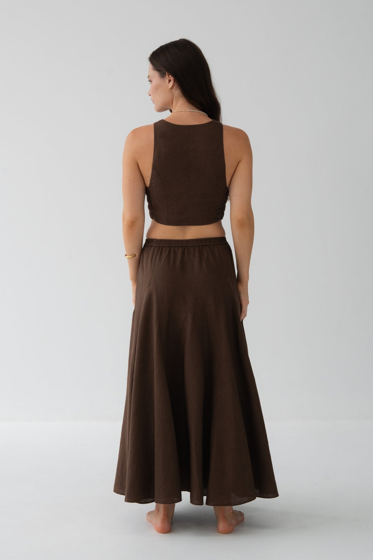 Stella Linen Maxi Skirt in Chocolate - back view, woman wearing matching Chocolate linen crop top, full A-line maxi silhouette, studio backdrop - Lilly Pilly Collection