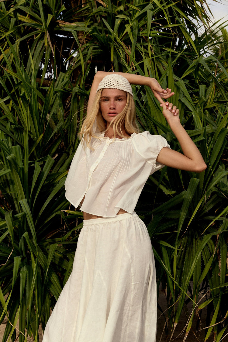 Stella Linen Maxi Skirt in Ivory - full length, woman wearing Ivory linen skirt with ivory pintuck crop top and woven headband, tropical foliage backdrop - Lilly Pilly Collection