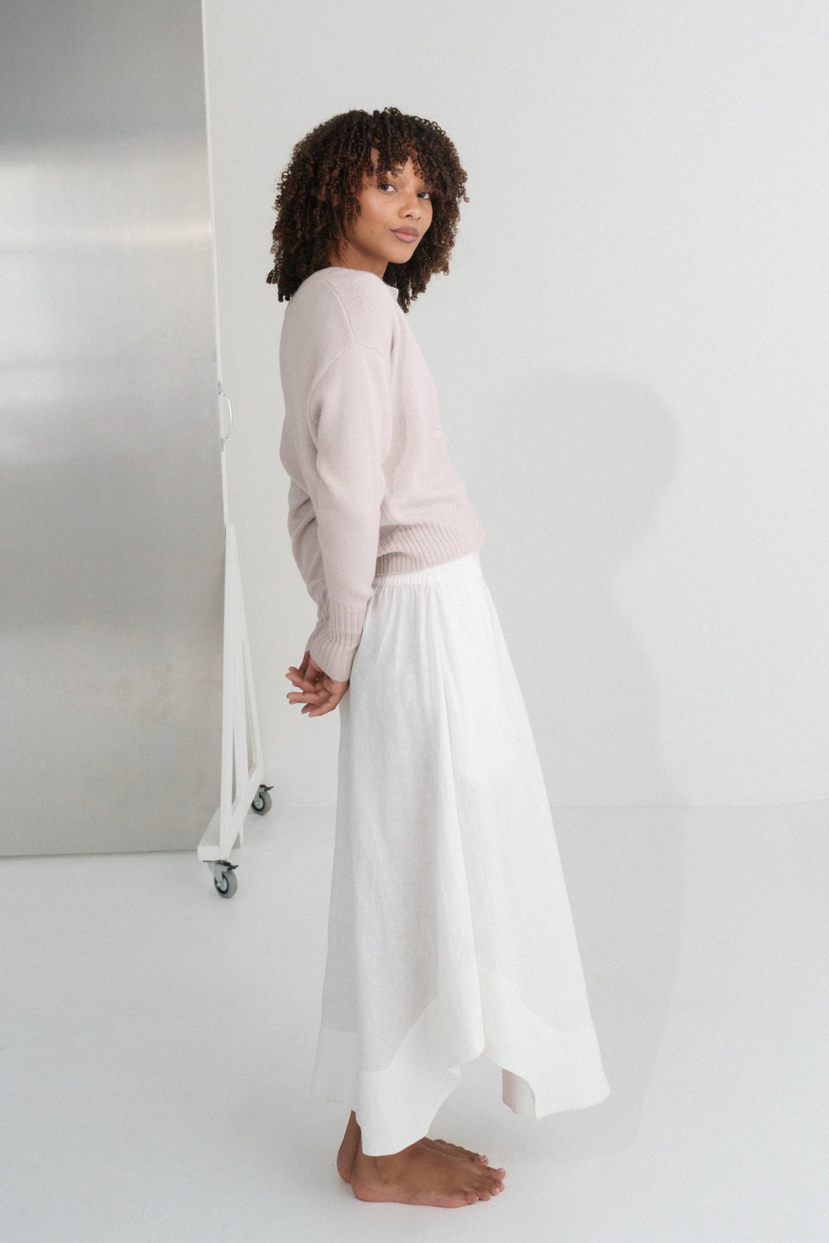 Side view of LILLY PILLY Taylor merino wool knit cardi in Lilac and ivory Hannah  skirt