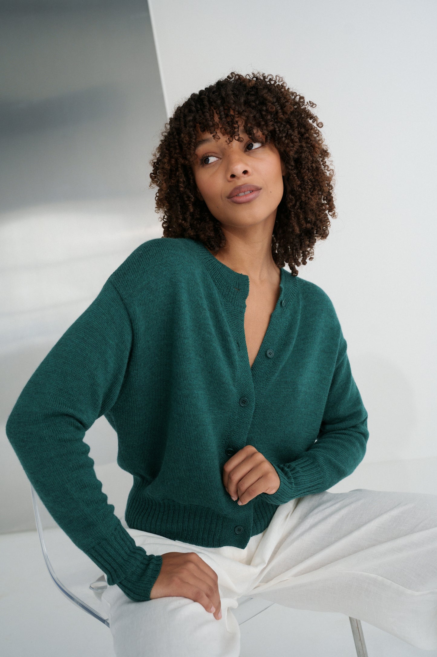 Close up front view of LILLY PILLY woman wearing pine green coloured Taylor merino knit cardigan 