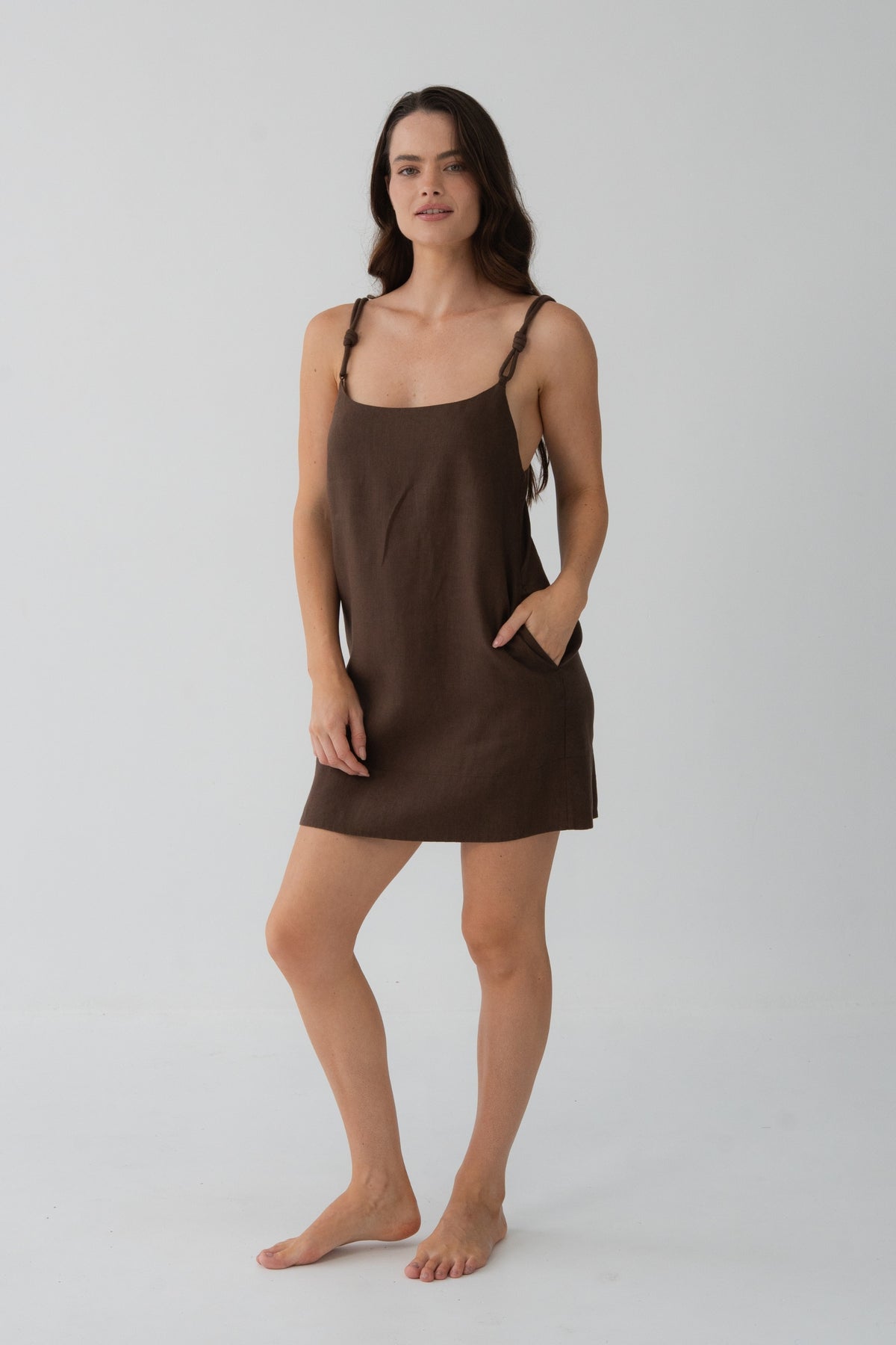 Tevi Linen Short Slip Dress in Chocolate - woman hand in pocket, relaxed short silhouette - Lilly Pilly Collection