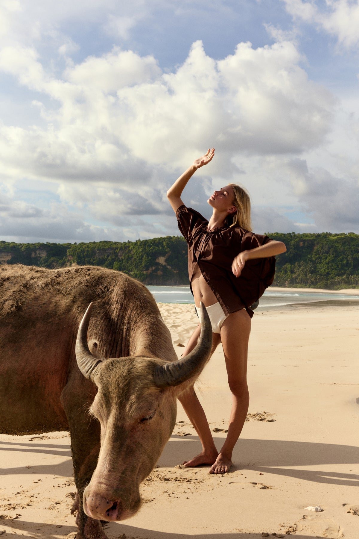 Thalia Cotton Voile Shirt in Chocolate - women on a beach with water buffalo, gathered neckline and balloon sleeves, worn open as beach cover-up - Lilly Pilly Collection
