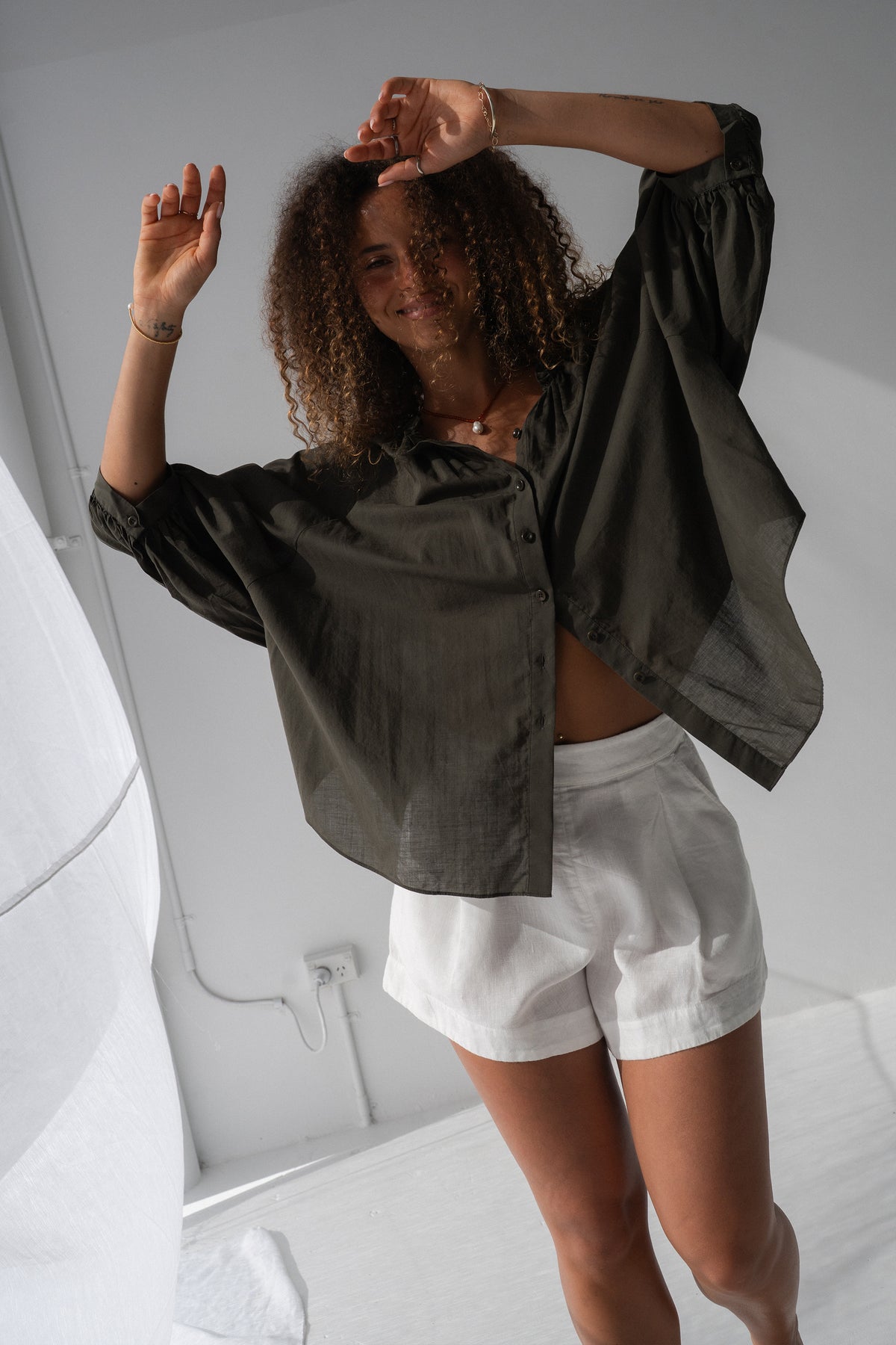 Thalia Cotton Voile Shirt in Khaki - side view, balloon sleeves, worn with white shorts - Lilly Pilly Collection