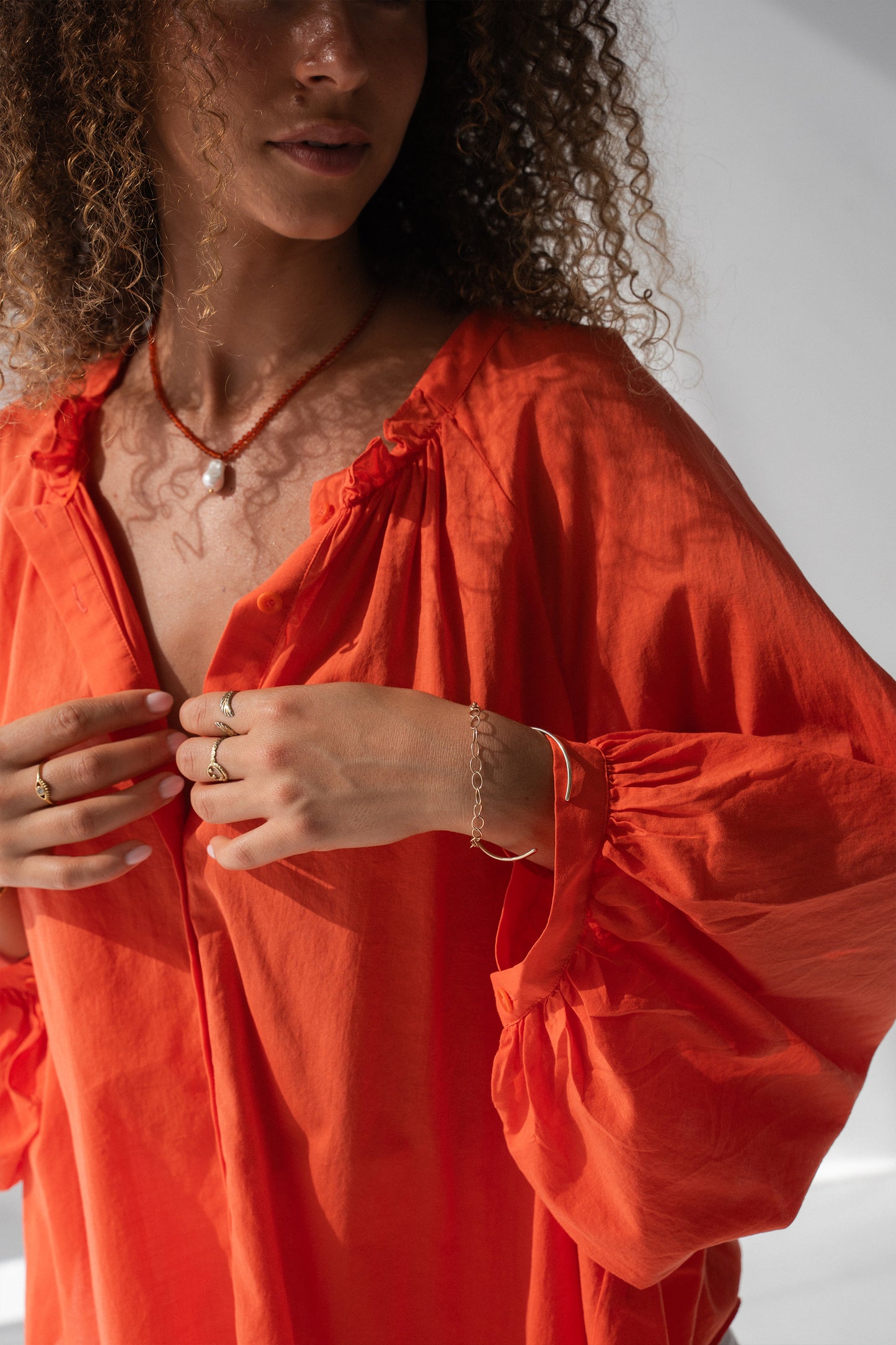 Thalia Cotton Voile Shirt in Spritz Orange - close-up of gathered ruffle neckline and balloon sleeve cuff detail, gold jewellery - Lilly Pilly Collection