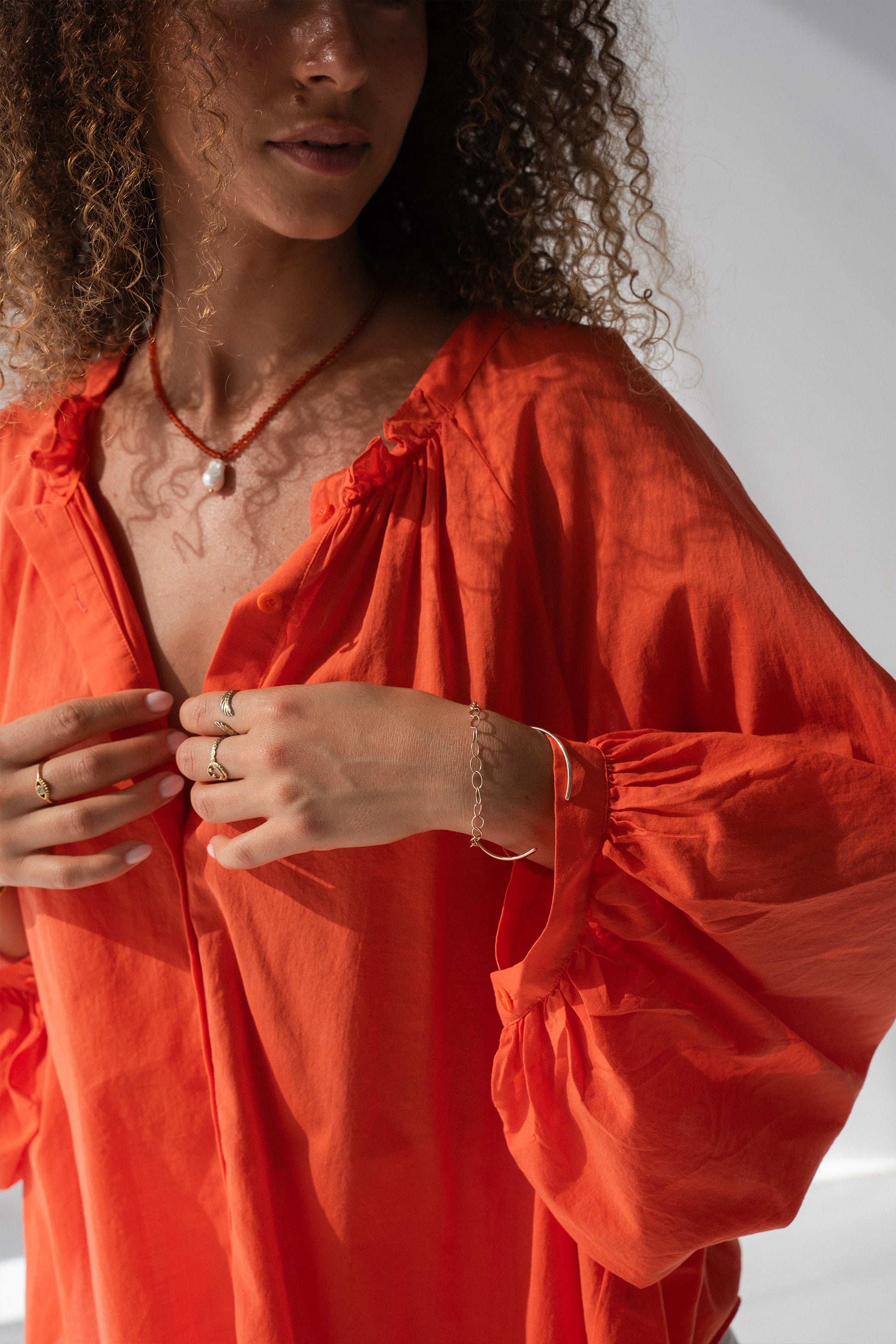 Thalia Cotton Voile Shirt in Spritz Orange - close-up of gathered ruffle neckline and balloon sleeve cuff detail, gold jewellery - Lilly Pilly Collection