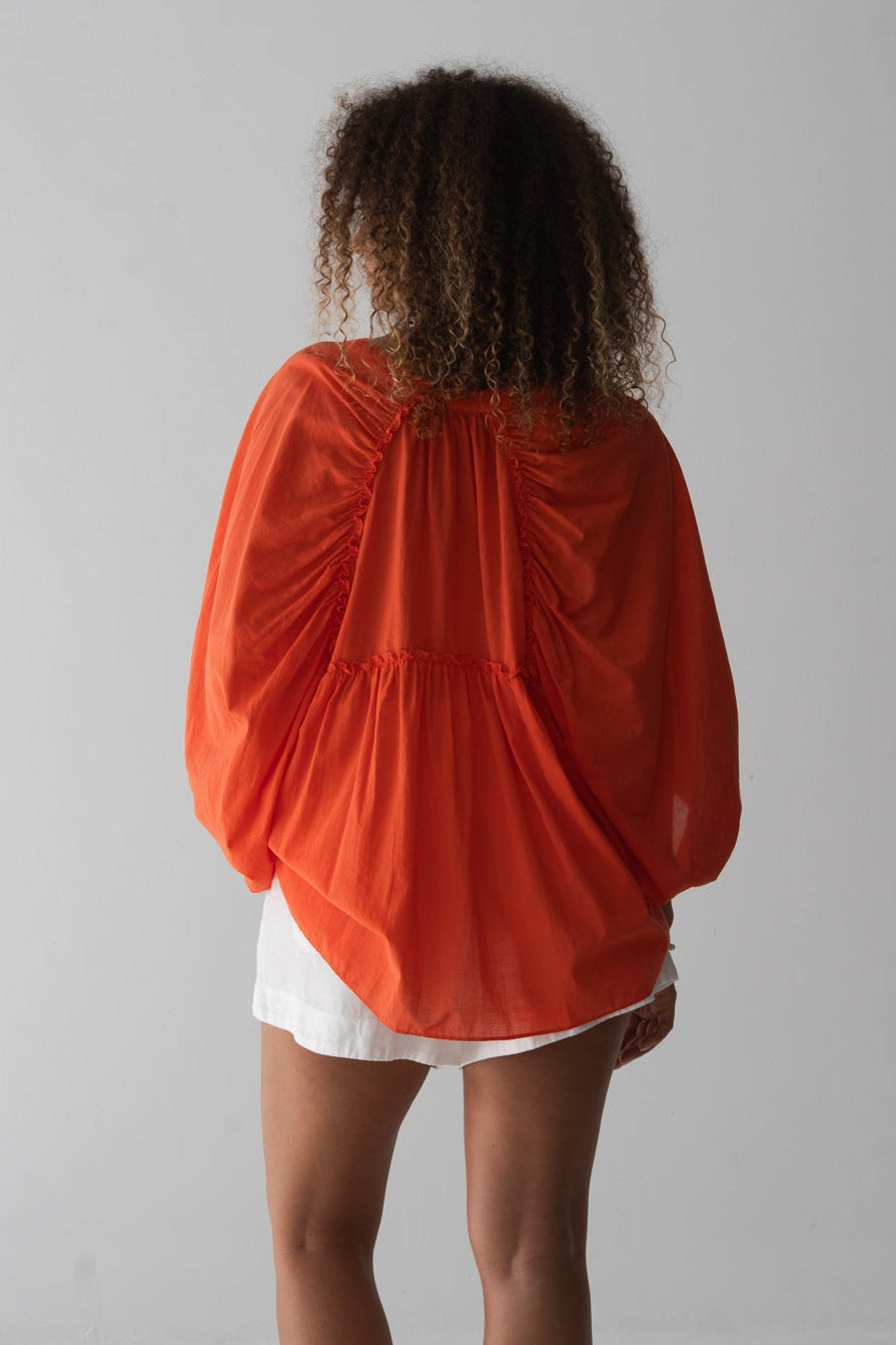 LILLY PILLY person wearing a spritz cotton voile Thalia top and ivory white Gaia linen shorts against a gray background
