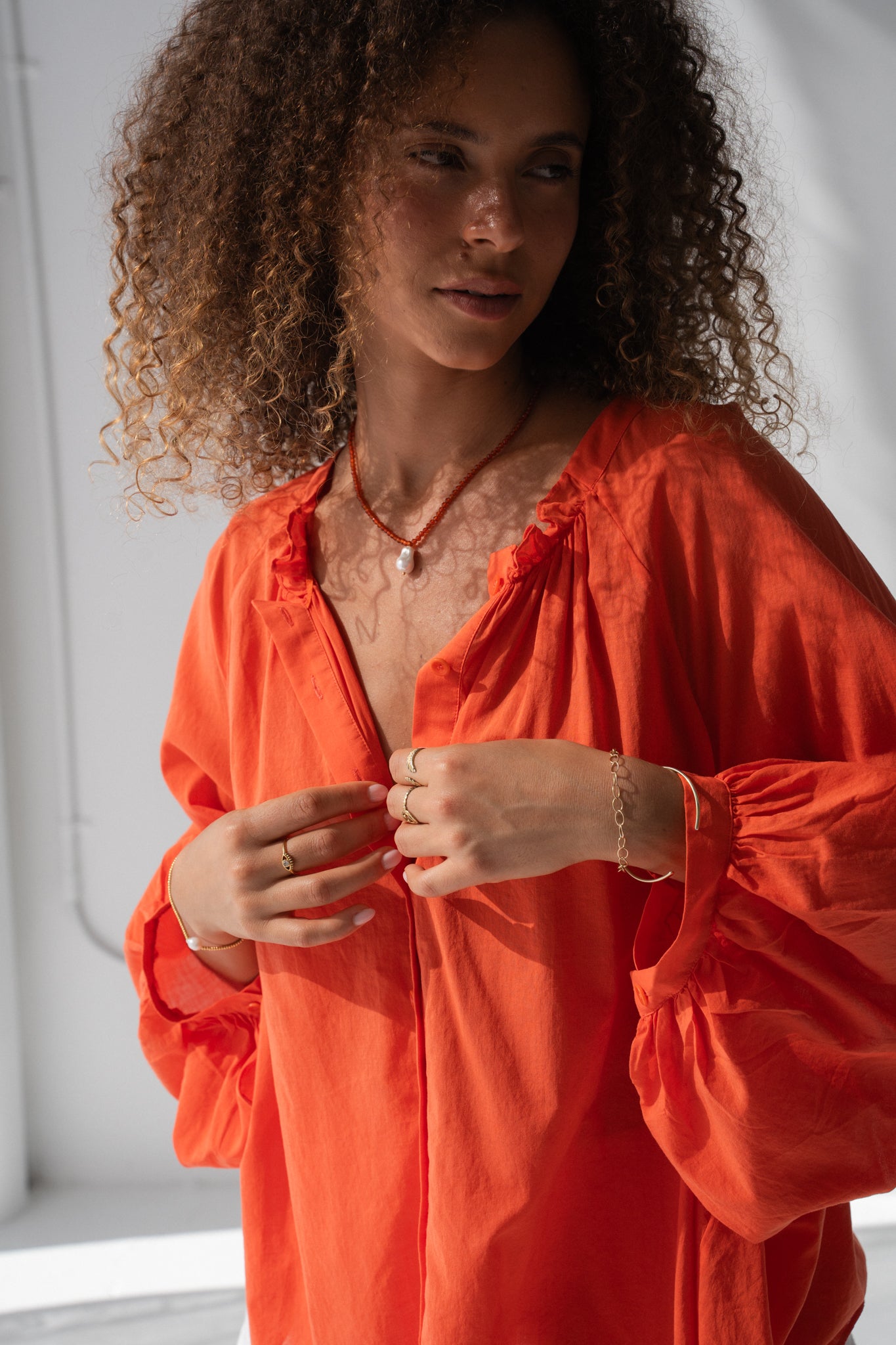 Close up view of LILLY PILLY person wearing a spritz cotton voile Thalia top against a gray background