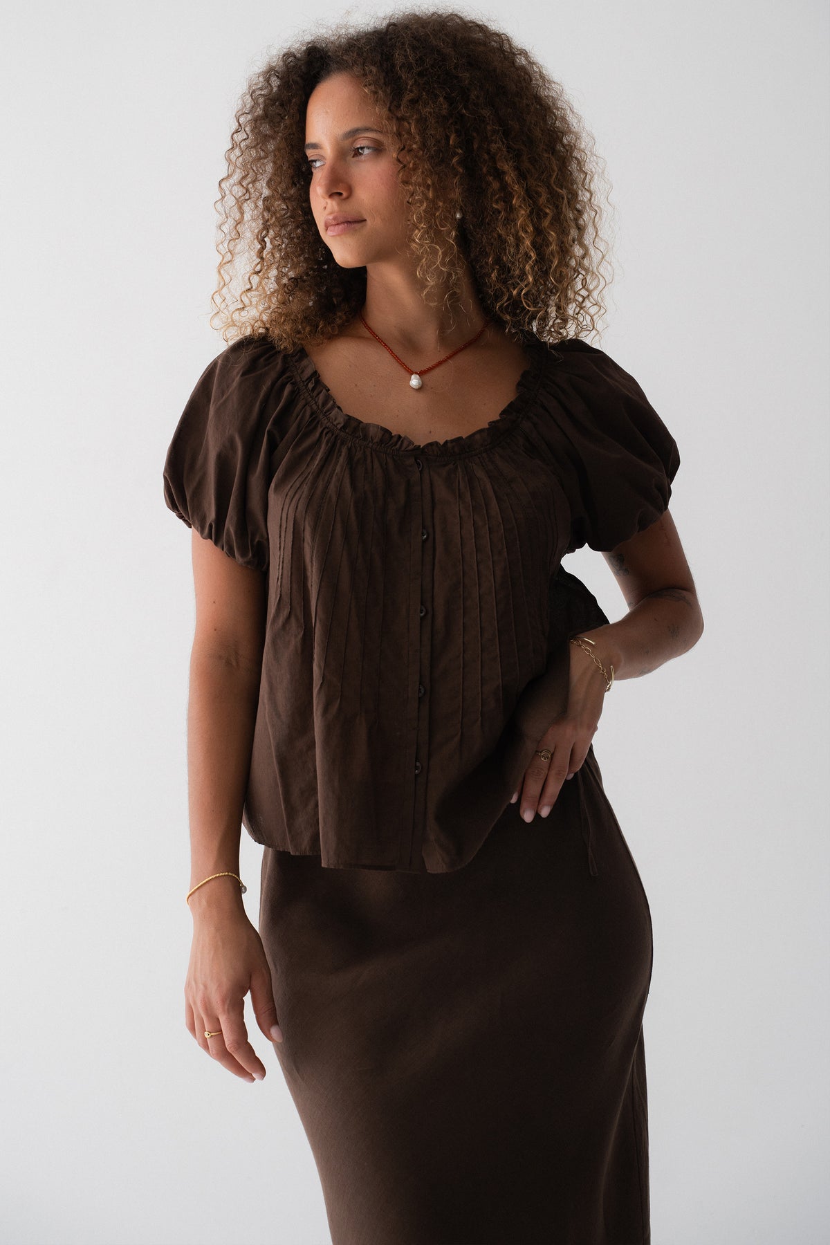Tilly Cotton Voile Shirt in Chocolate - three-quarter view, gathered ruffle neckline and pintuck detail, puff sleeves, worn with matching Riley Bias Linen Midi Skirt in Chocolate - Lilly Pilly Collection