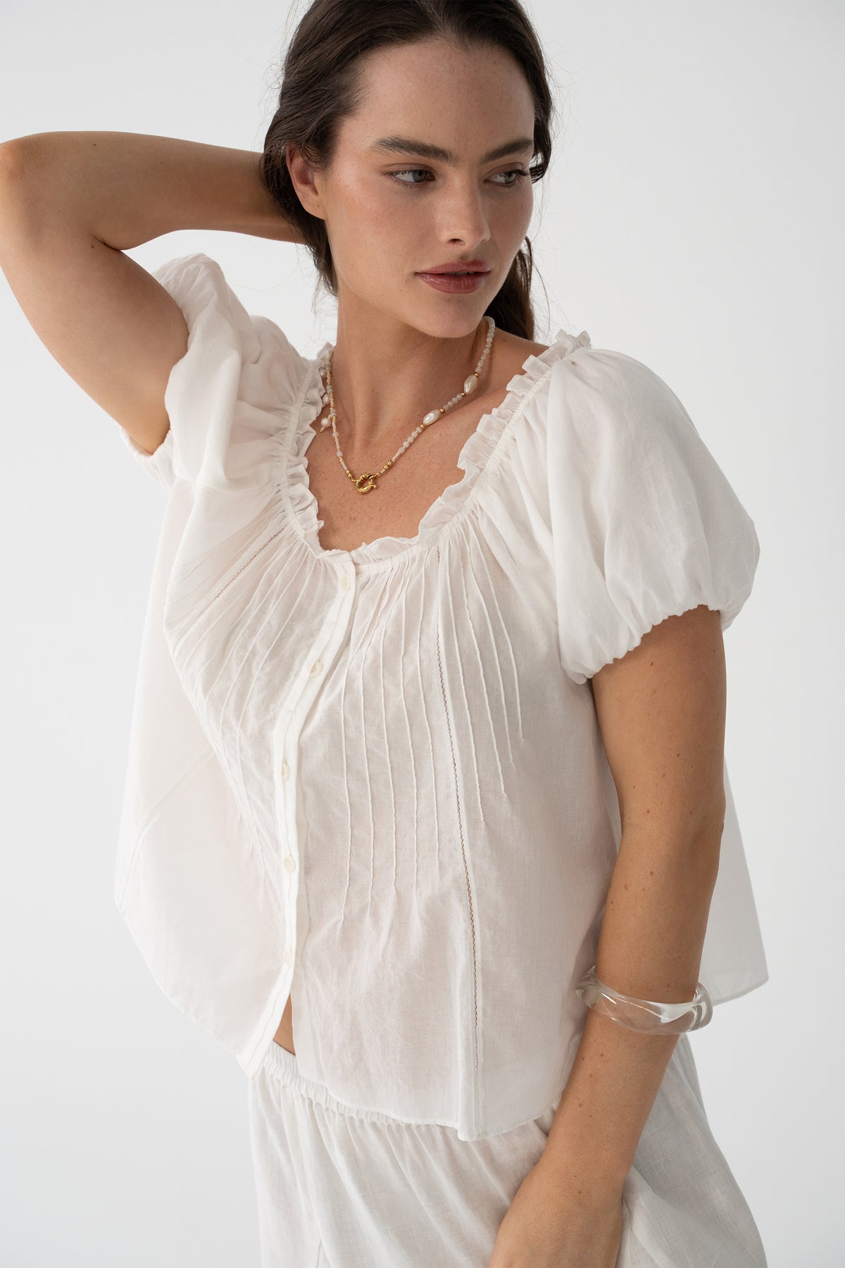 Tilly Cotton Voile Shirt in Ivory - close-up, ruffle neckline and pintuck detail, arms raised, - Lilly Pilly Collection