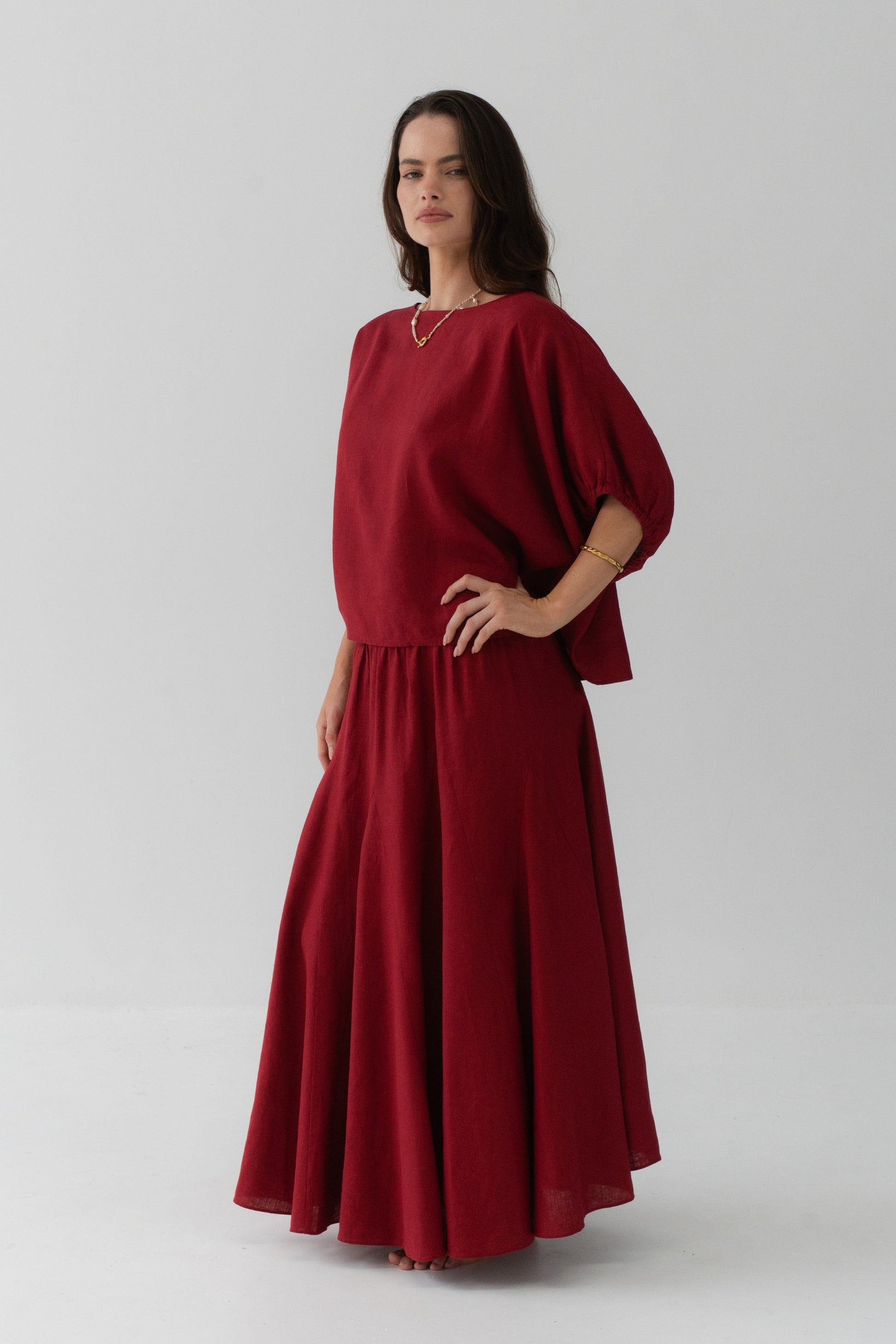 Tina Linen Top in Cherry Red - three-quarter view, oversized batwing silhouette, hand on hip, styled with matching Riley Linen maxi skirt - Lilly Pilly Collection