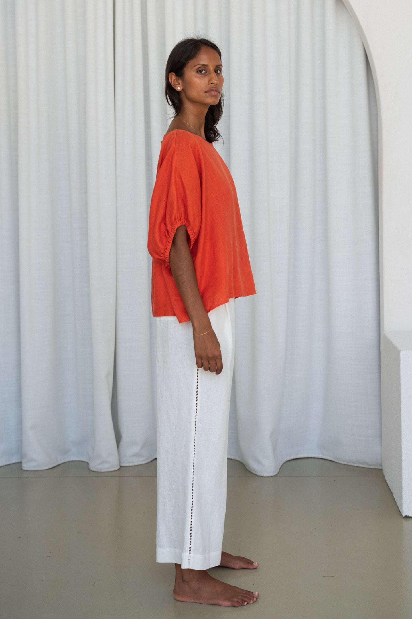 Person wearing a Leia linen top in Spritz and ivory Oli linen pants side view