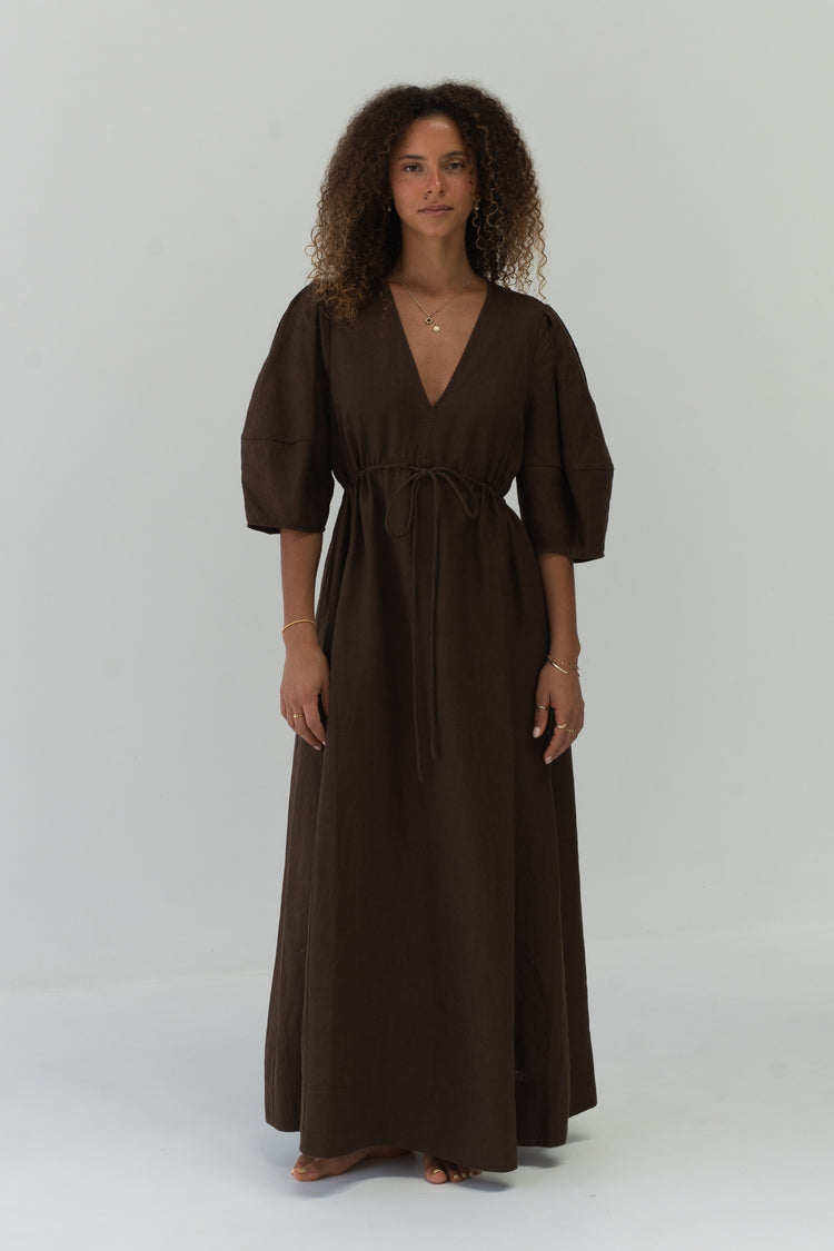 Front view of a woman wearing the Vida Linen maxi dress in Chocolate in a studio - Lilly Pilly Collection