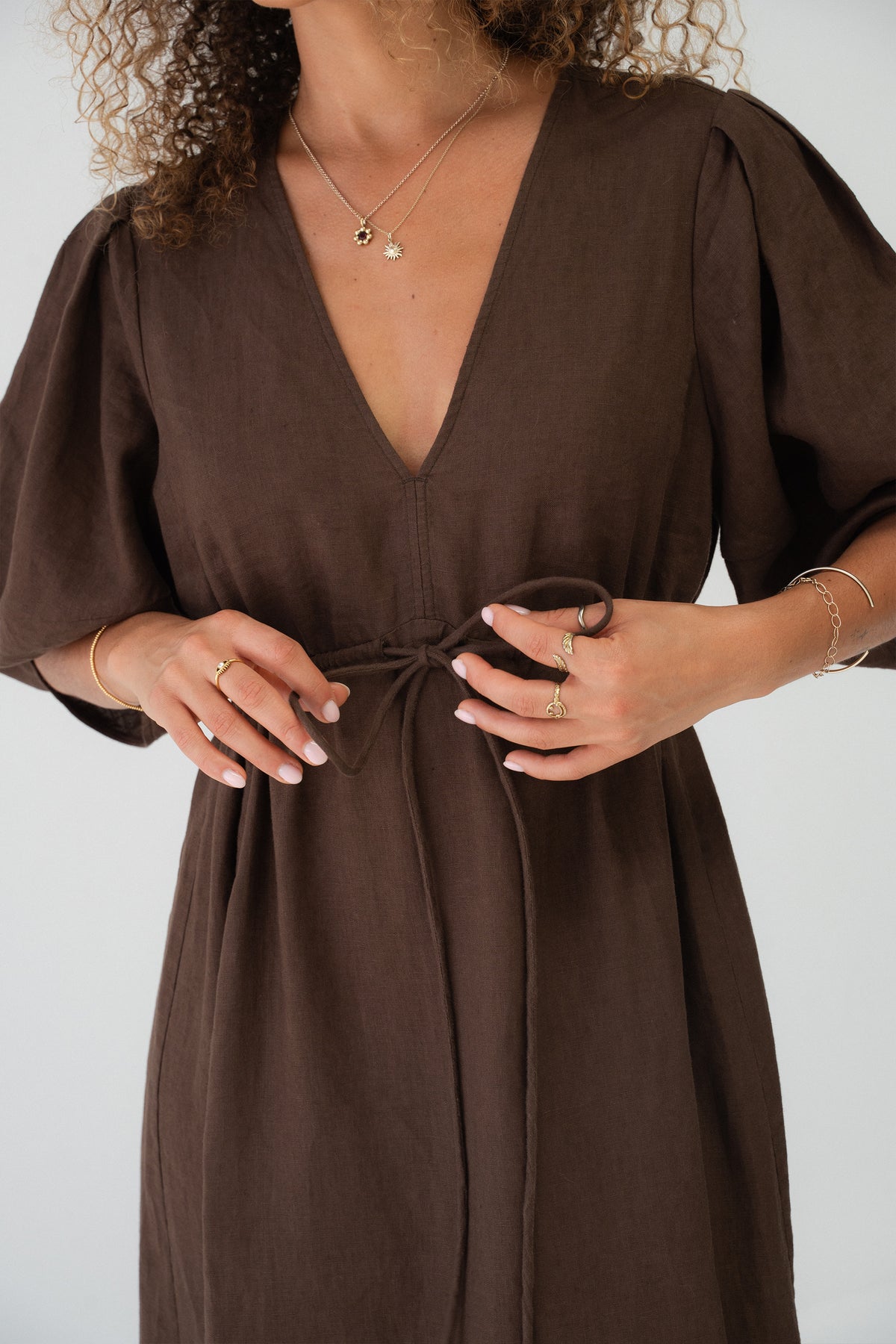 Close up view of a woman wearing the Vida Linen maxi dress in Chocolate in a studio setting - Lilly Pilly Collection