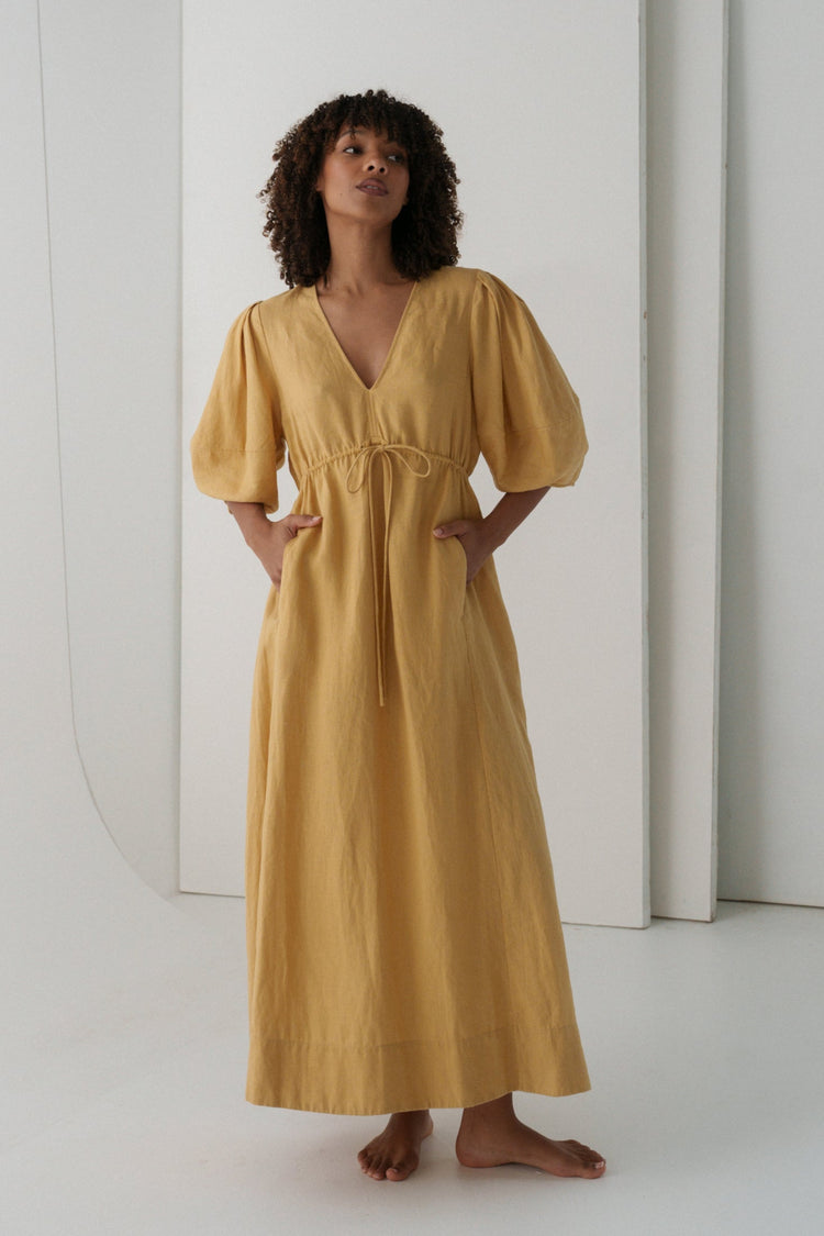 Front view a woman wearing the Vida Linen maxi sleeve dress in Sand Beige - Lilly Pilly Collection