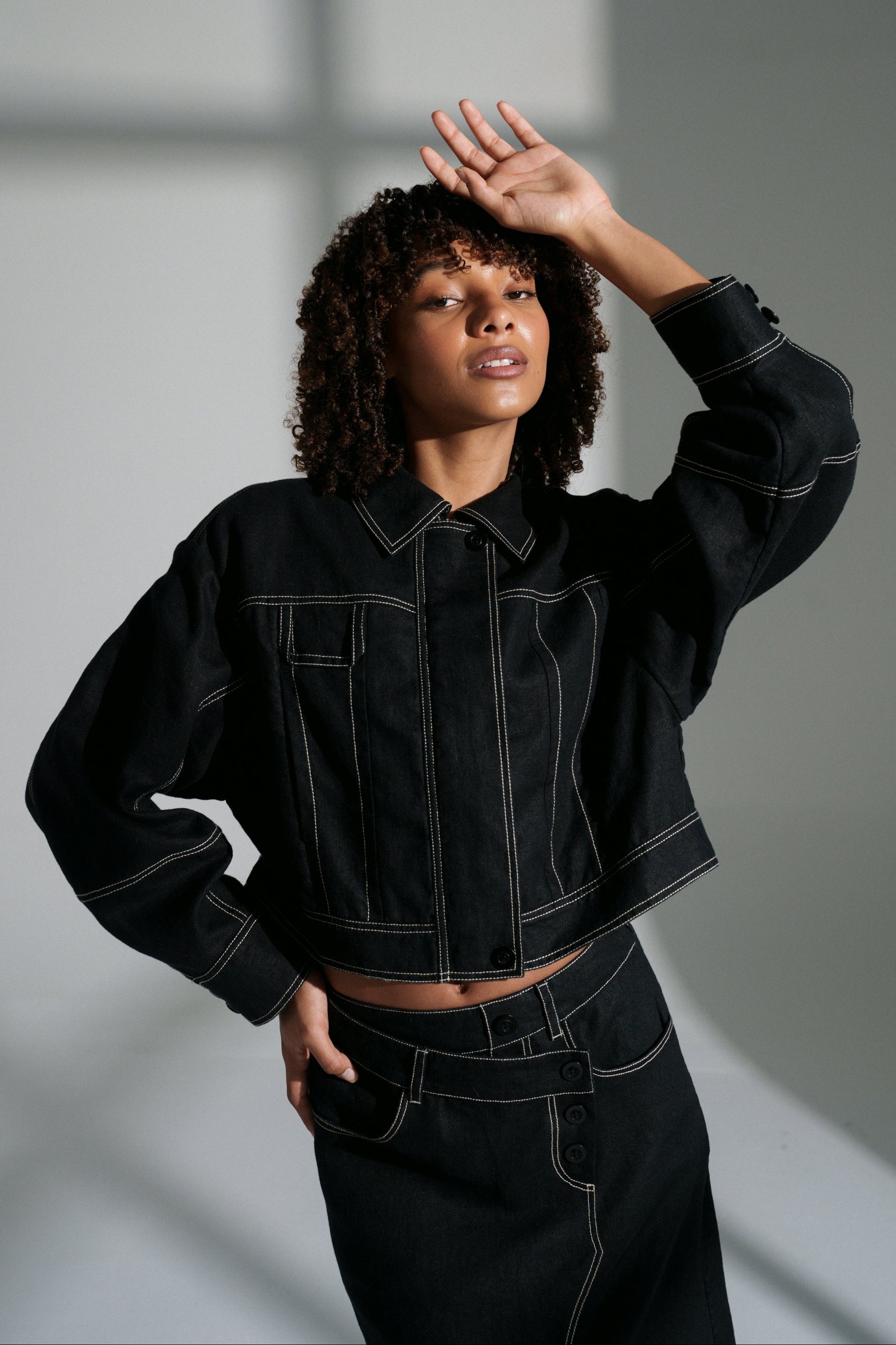 LILLY PILLY woman wearing a black Wes linen jacket against a neutral background