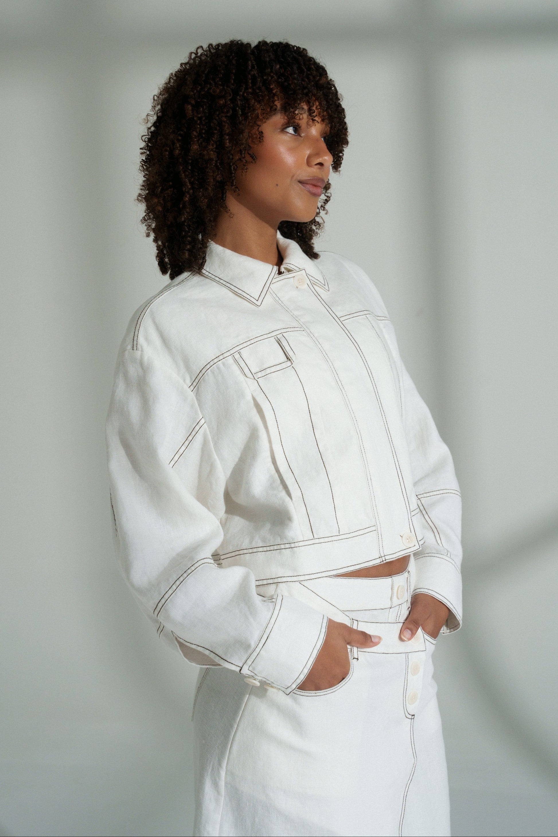 LILLY PILLY woman wearing an ivory Wes linen jacket against a neutral background
