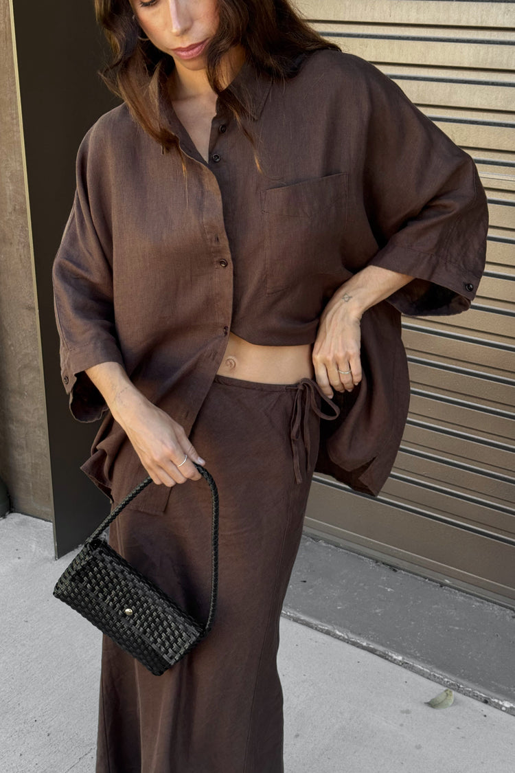 Pixie Linen Shirt in Chocolate - side view paired with matching Riley linen skirt while adjusting skirt waist tie - Lilly Pilly Collection