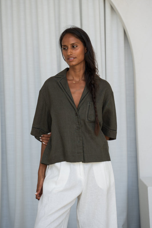 LILLY PILLY woman wearing a Pixie linen shirt in khaki by an archway