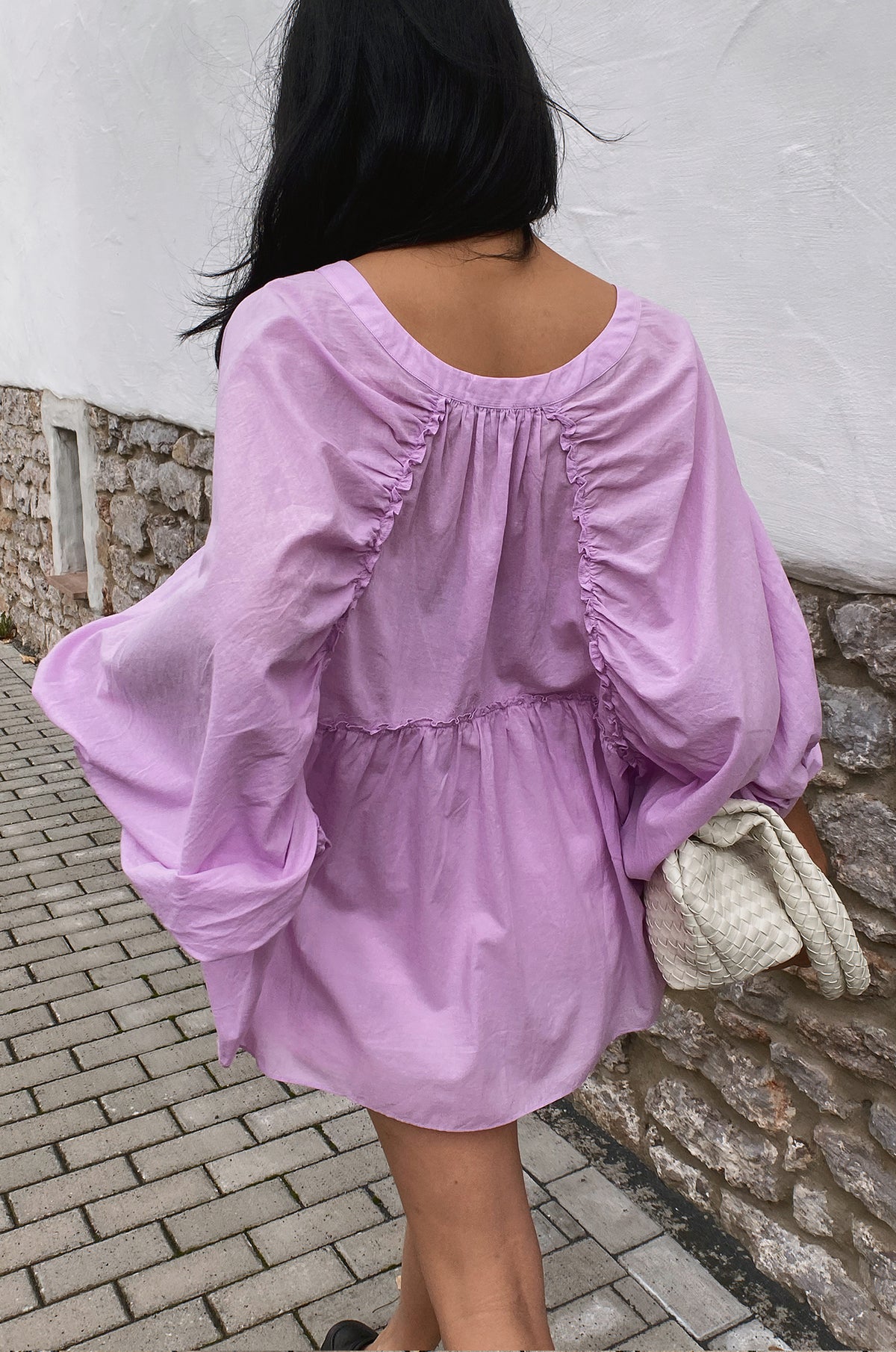 Close up back view of LILLY PILLY woman wearing a orchid Thalia cotton voile shirt  while walking down the footpath.