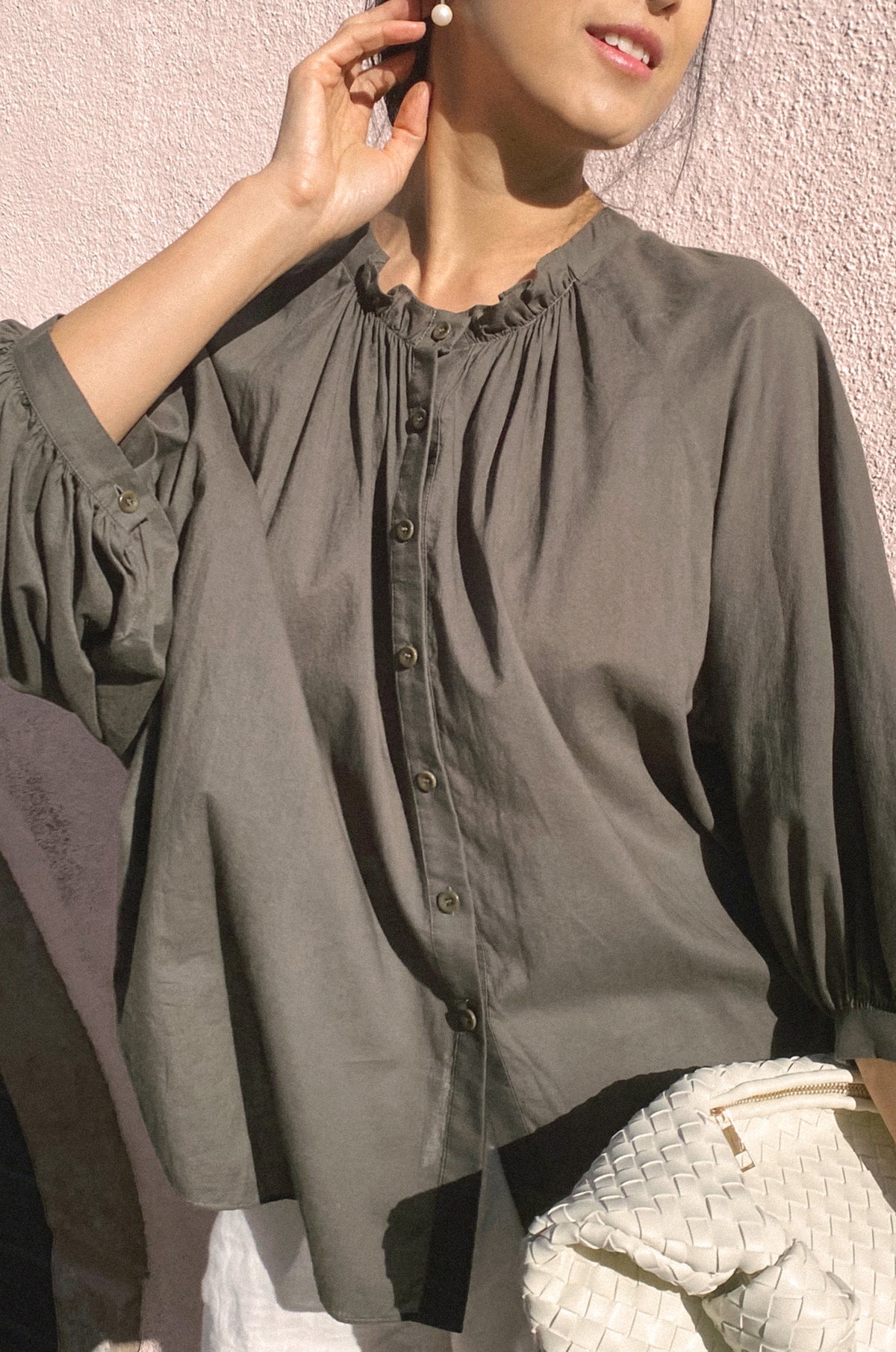 Person wearing a green blouse with a textured background