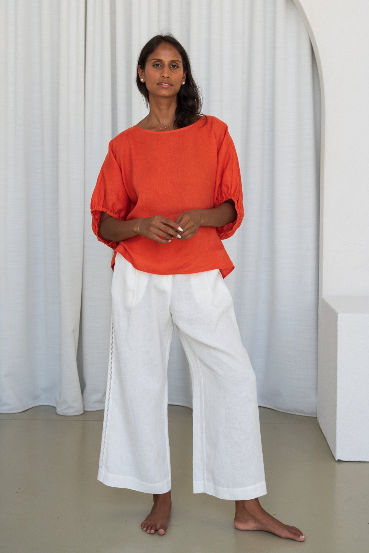 Person wearing a Leia linen top in Spritz and ivory Oli linen pants front view